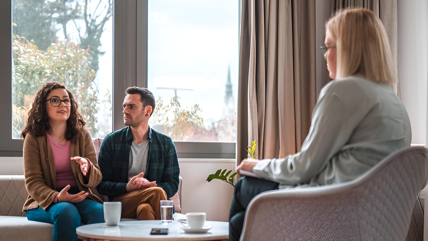 The therapist and client are having a calm, open conversation in a cozy therapy room